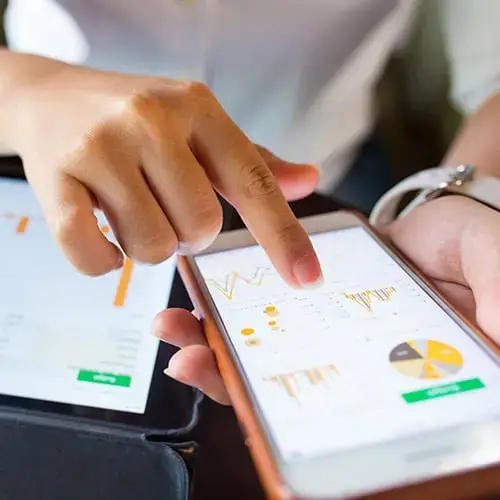 Person analyzing marketing data on a mobile device, representing Exceedion, an Indianapolis marketing agency focused on data-driven strategies.